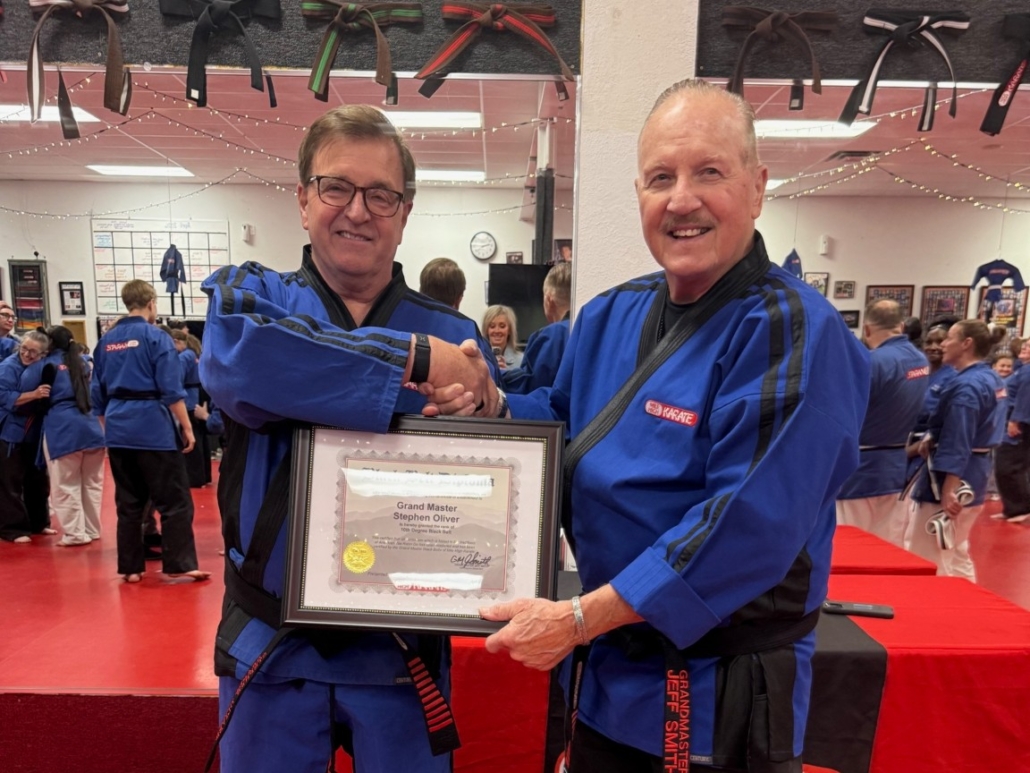 Grand Master Jeff Smith presenting Grand Master Stephen Oliver with his 10th Degree Black Belt diploma at Mile High Karate
