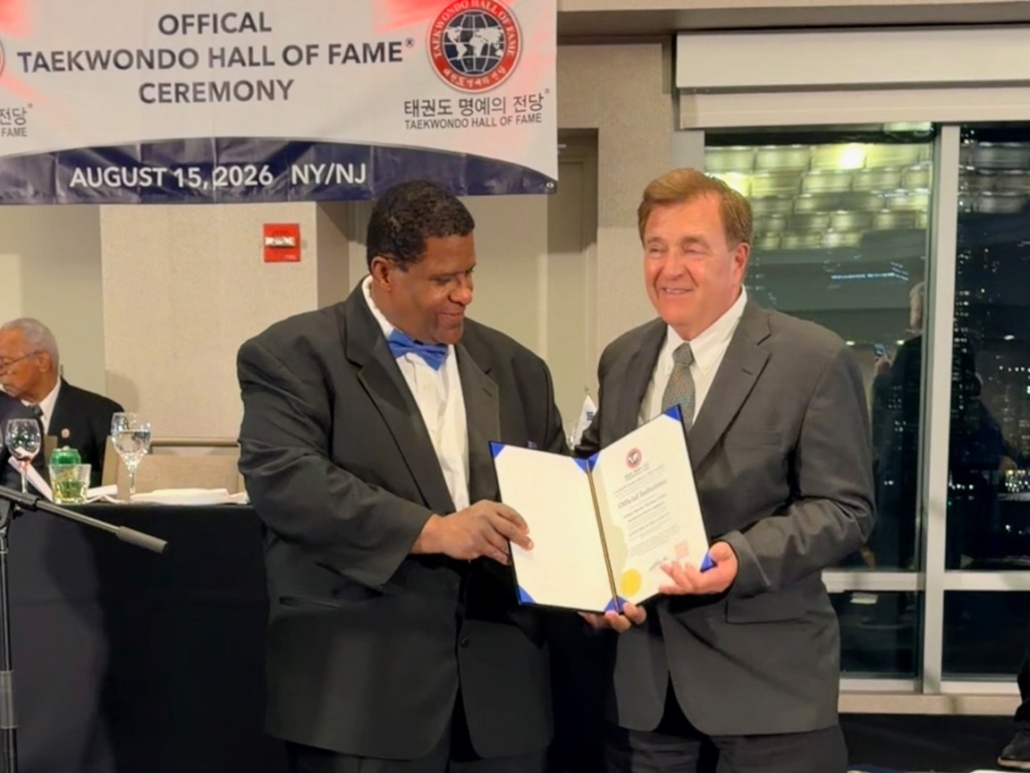 Stephen Oliver receiving his Official Induction certificate at the Official Taekwondo Hall of Fame ceremony, August 15, 2026, NY/NJ